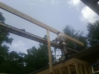 Carpenter setting a ridge beam over a new addition frame — Ice Dam Removal by Roofing Brothers in Bushkill