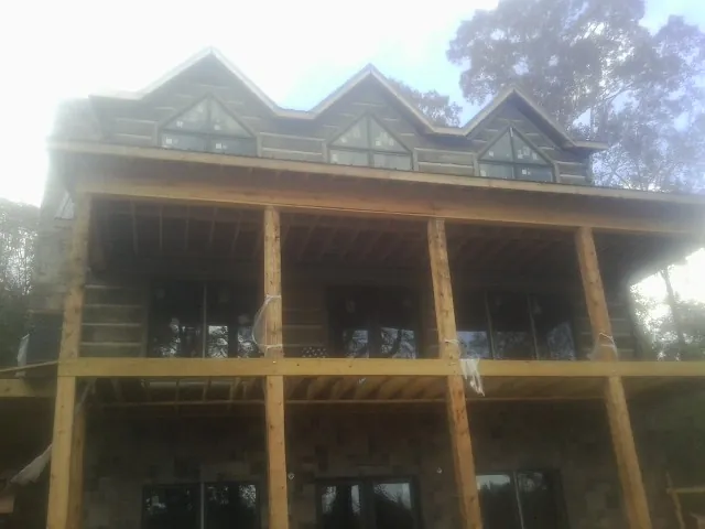 Dormers and porch framing on a large log home under construction — Roof Coating work by our crew in Bushkill