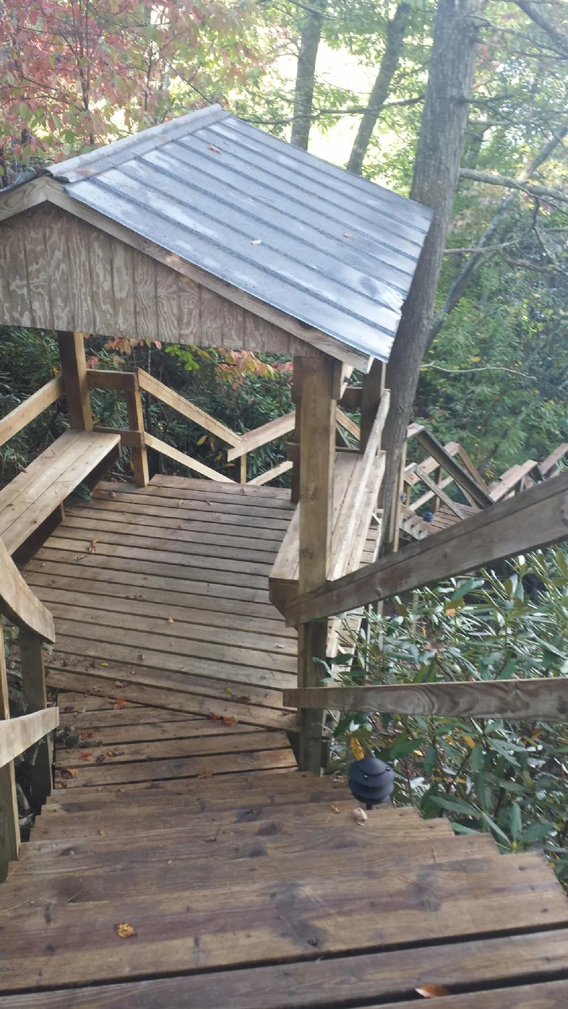 Metal roofed shelter over wooden steps on a wooded walkway — Skylight Repair & Installation work by our crew in Bushkill
